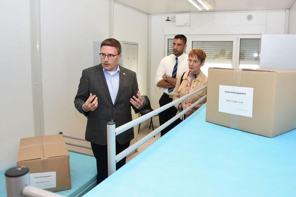 Bild vergr&ouml;&szlig;ern: Das Foto zeigt Landrat Christoph Schauder, Sozialdezernentin Elisabeth Krug und Bürgermeister Nick Schuppert bei der Besichtigung eines der Zimmer für drei Bewohner in der Gemeinschaftsunterkunft Weikersheim.