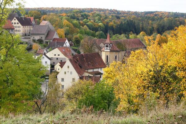 Herbstlicher Blick auf die Klosterkirche Frauental bei Creglingen: Das Kloster ist eines von sechs Klosteranlagen im "Lieblichen Taubertal".