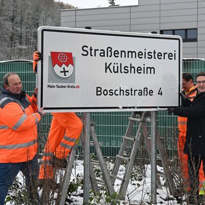 Der Leiter der Straßenmeisterei Külsheim, Martin Winkler, sowie Landrat Christoph Schauder brachten gemeinsam mit zwei Mitarbeitern der Straßenmeisterei das neue Schild an.