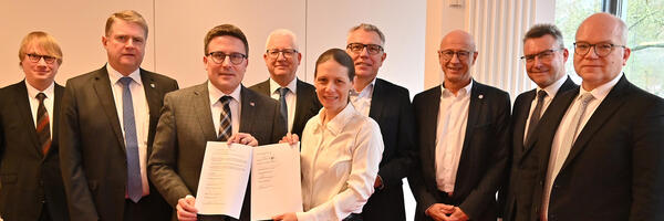 Die sieben Gesellschafter halten gemeinsam mit Notarin Natascha Both und dem Gr�ndungsgesch�ftsf�hrer Tobias Wurm (links) den unterschriebenen Gesellschaftsvertrag in den H�nden: Die Tourimia Tourismus GmbH ist gegr�ndet.
