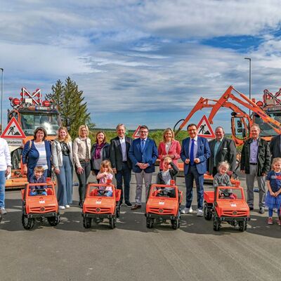 Ein fahrbarer Untersatz für die sechs Kindertagesstätten in Külsheim: Im Anschluss an den Tag der offenen Tür wechseln die Tret-Unimogs, die bei der Eröffnung auf der Spielstraße zum Einsatz kamen, in den Besitz der Kindertagesstätten. Landrat Christoph Schauder übergab die Exemplare im Rahmen der Feierlichkeit an die Kita-Leitungen.