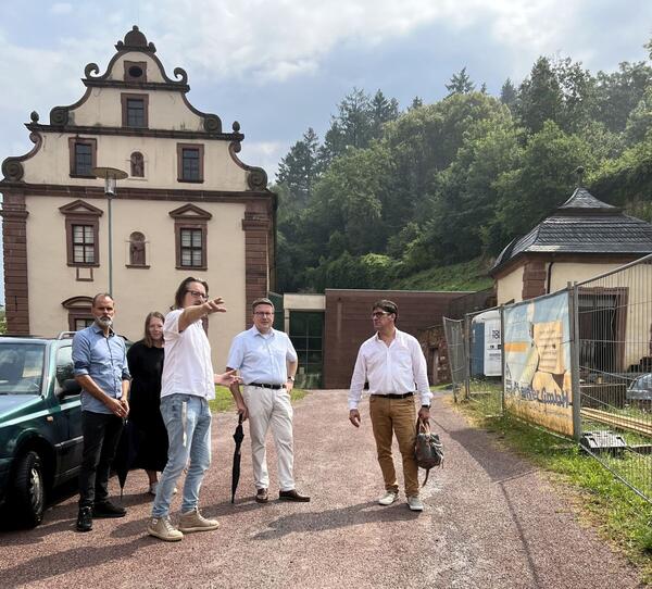 Bild vergr&ouml;&szlig;ern: Das Foto zeigt Amtsleiter Joachim Aragón, Projektleiterin Kerstin Sack (beide Immobilienmanagement Landratsamt), Archäologe Matthias Klefenz, Landrat Christoph Schauder und Architekt Michael Bannwarth im Gespräch: Die Beteiligten besichtigten die Baustelle im Saalgarten.
