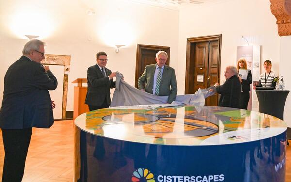 Freuen sich ber die innovative Mglichkeit, das Wirken der Zisterziensermnche zu erkunden: Alfred Beetz (v.l.n.r), 1. Vorsitzender der Aktionsgruppe LEADER Badisch Franken e.V., Landrat Christoph Schauder, Landrat Johann Kalb aus Bamberg und Altlandrat Georg Denzer enthllen das neue 3D-Landschaftsmodell.
