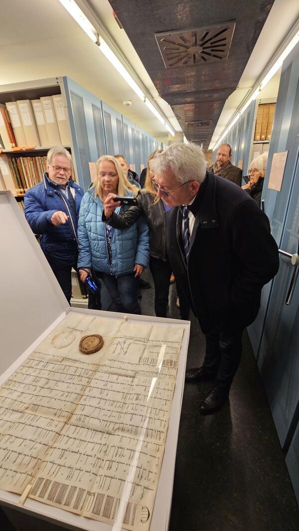 Teilnehmer des Lenkungskreises Cisterscapes bei der F�hrung im Archivverbund Main-Tauber. Landrat Johann Kalb aus Bamberg (rechts) betrachtet die Gr�ndungsurkunde des Klosters Bronnbach.