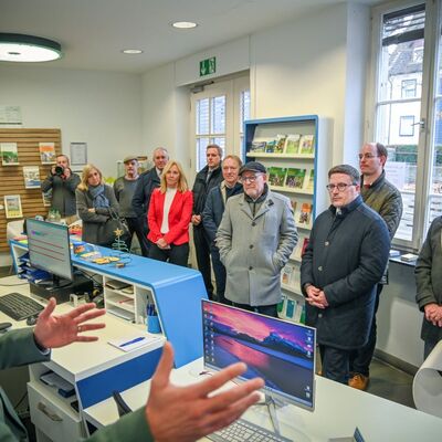 Gemeinsamer Rundgang durch die Mobilit�tszentrale in Lauda: Landrat Christoph Schauder (3.v.r.) und Verkehrsminister Winfried Hermann (4.v.r.) informieren sich gemeinsam mit der Bundestagsabgeordneten Nina Warken (3.v.l.) und Fraktionsvorsitzenden des Kreistags bei VGMT-Gesch�ftsf�hrer Thorsten Haas �ber das Beratungs- und Dienstleistungsangebot der Mobilit�tszentralen im Landkreis.