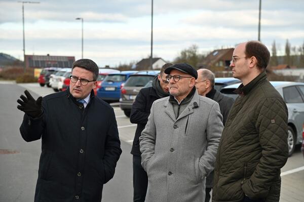 Bild vergr&ouml;&szlig;ern: Das Foto zeigt Landrat Christoph Schauder und Verkehrsminister Winfried Hermann gemeinsam mit Dr. Lukas Braun, Bürgermeister der Stadt Lauda-Königshofen, beim gemeinsamen Rundgang über das modernisierte Bahnareal in Lauda.