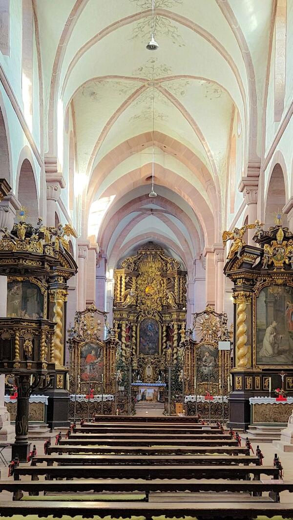 Das Foto zeigt den Innenraum der Klosterkirche Bronnbach, den Abt Joseph Hartmann wesentlich umgestaltete, unter anderem durch die Neuanschaffung mehrerer Altäre sowie den Ersatz der vorherigen steinernen Chorschranke durch ein filigranes Gitter.