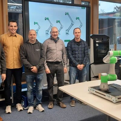 Bild vergr&ouml;&szlig;ern: Dieses Foto zeigt Mathias Fleckenstein (Schneider Electric), Christopher Gebert, Sebastian Walter (Schneider Electric), Schulleiter Manfred Breuer und Markus Dörr bei der Übergabe des Cobots im SmartLab 4.0 des Beruflichen Schulzentrums Wertheim.