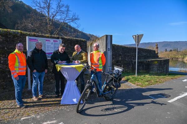 Landrat Christoph Schauder (dritter von links) und B�rgermeister Roger Henning (vierter von links) unterzeichnen die Vereinbarung. Dar�ber freuen sich auch Michael Suppinger (Stra�enbauamt Main-Tauber-Kreis), Bauamtsleiter Klaus Weimer (Stadt Freudenberg) und Stra�enbauamtsleiter Markus Metz (Main-Tauber-Kreis).