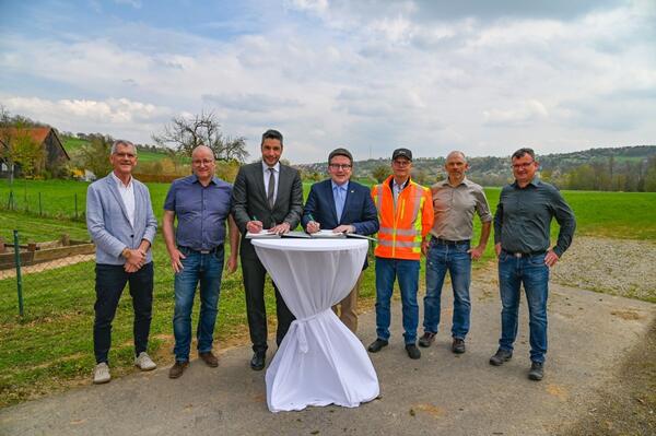 Landrat Christoph Schauder (vierter von links) und B�rgermeister Nick Schuppert (f�nfter von links) unterzeichnen die Vereinbarung. Dar�ber freuen sich auch Technik-Dezernent Werner R�ger (von links), Ortsvorsteher Hans-Joachim Haas, Stra�enbauamtsleiter Markus Metz, Sebastian Bokmeier (beide Main-Tauber-Kreis) und J�rgen Stilling (Bauamt Stadt Weikersheim).