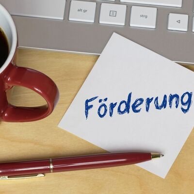 Bild vergr&ouml;&szlig;ern: Das Foto zeigt einen Zettel, auf dem das Wort "Förderung" steht und der auf einer Computertastatur liegt.
