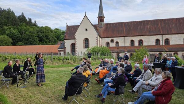 Geschichtenerz�hlerin Anja Koch (v.l.) im Klosterweinberg vor der Klosterkirche Bronnbach. Die Besucherinnen und Besucher des neuen Formats "Erz�hlabend mit M�rchen und Geschichten" haben die Premierenveranstaltung genossen.