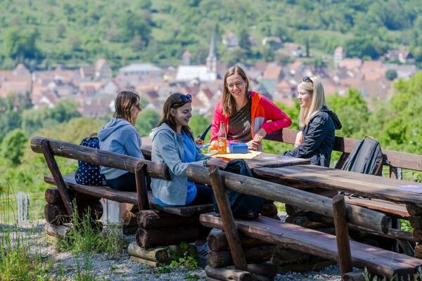 Eine Wandergruppe genie�t ein Picknick auf dem Panoramaweg mit sch�ner Aussicht auf R�ttingen: Auf Wander- und Radtouren durch das Liebliche Taubertal gilt es, weitere sch�ne Picknickpl�tze f�r sich zu entdecken.
