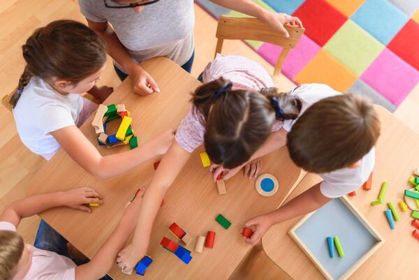 Das Foto zeigt Kinder, die mit Bauklötzen spielen.
