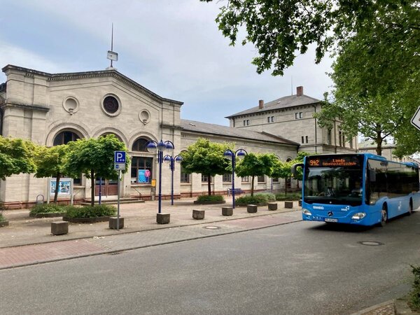 Das Foto zeigt einen Bus der Linie 942 vor dem Bahnhofsgebäude in Lauda. 