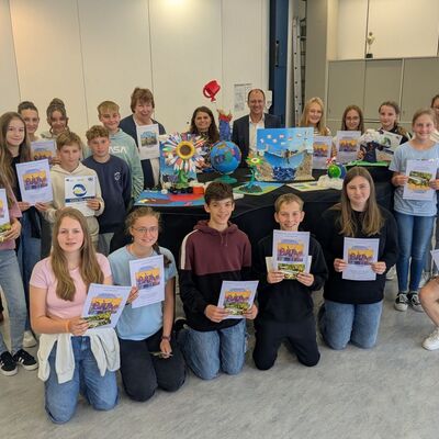 Preisübergabe Weikersheim: Silvia Ziegler (Landratsamt Main-Tauber-Kreis) und Thomas Kohlschreiber (Sparkasse Tauberfranken) freuen sich mit den Preisträgerinnen und Preisträgern am Gymnasium Weikersheim.