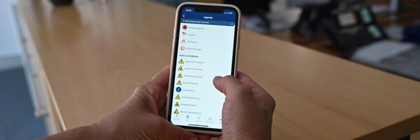 Das Bild zeigt ein Smartphone auf dem eine Warn-App ge�ffnet ist.