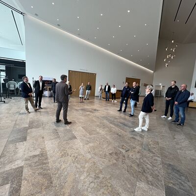 Die Besucher aus Bautzen gemeinsam mit Landrat Christoph Schauder und Intendant Johannes Mnich im Sparkassen-Foyer der TauberPhilharmonie in Weikersheim.