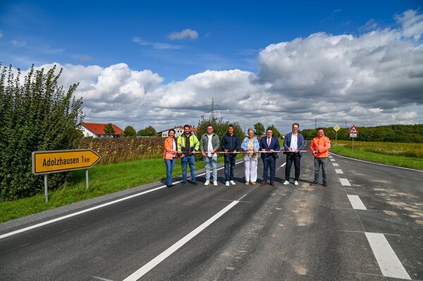 Beim Durchschneiden des Bandes anl�sslich der neuen Fahrbahndecke auf der K 2853 zwischen der Abzweigung von der B 290 bis zum Ma�weg in der Ortsdurchfahrt Adolzhausen (von links): Hanna Kuznetsova (Stra�enbauamt), Bauleiter Timo Gra�m�ller (Firma Ernst H�hnlein), Bauamtsleiter Sebastian Mayer (Stadt Niederstetten), stellvertretender Ortsvorsteher Manuel Hainke, B�rgermeisterin Heike Naber, Landrat Christoph Schauder, Gesch�ftsf�hrer Ralf Puchinger (Firma Ernst H�hnlein) sowie der Leiter der Stra�enmeisterei Bad Mergentheim, Michael Baun.