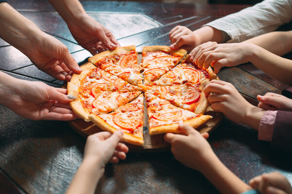 H&auml;nde greifen nach Pizzast&uuml;cken