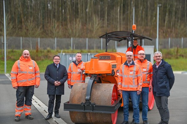 Bild vergr&ouml;&szlig;ern: Das Foto zeigt Landrat Christoph Schauder gemeinsam mit Straßenwärter Michael Fröhlich, dem stellvertretenden Amtsleiter Dirk Borsdorf, Amtsleiter Markus Metz, Dezernent Technik Werner Rüger, Leiter der Straßenmeisterei Külsheim Martin Winkler sowie Marcel Elleser mit einer alten Motorenstraßenwalze aus dem Jahr 1963.