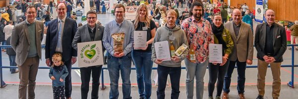 Das Foto zeigt Ersten Landesbeamten Florian Busch, Bürgermeister Dr. Lukas Braun, Landrat Christoph Schauder mit Vertretern des Bisonhofs Nuß (ausgezeichnetes Produkt: Kartoffel), dem Bioland Hof Klein (ausgezeichnete Produkte: Birnensaft sowie Lupinenmehl und -flocken) sowie dem Weingut Oskar Tag (ausgezeichnetes Produkt: Pétillant Naturel). Mit auf dem Bild Manuela Schnurr, Regionalmanagerin der Bio-Musterregion, Reinhard Friedrich, Kreisvorsitzender des Bauernverbands Main-Tauber-Kreis e.V., sowie Marcus Köhler, Leiter des Landwirtschaftsamtes. 