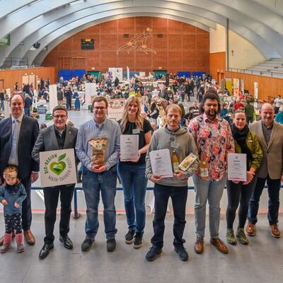 Im Rahmen der Messe wurden vier Produkte mit dem Qualit�tssiegel "Bio-Region Main-Tauber-Kreis" ausgezeichnet. Gemeinsam mit dem Ersten Landesbeamten Florian Busch (v.l.) und B�rgermeister Dr. Lukas Braun gratulierte Landrat Christoph Schauder dem Bisonhof Nu� (ausgezeichnetes Produkt: Kartoffel), dem Bioland Hof Klein (ausgezeichnete Produkte: Birnensaft sowie Lupinenmehl und -flocken) sowie dem Weingut Oskar Tag (ausgezeichnetes Produkt: P�tillant Naturel). Mit ihnen freuten sich Manuela Schnurr, Regionalmanagerin der Bio-Musterregion, Reinhard Friedrich, Kreisvorsitzender des Bauernverbands Main-Tauber-Kreis e.V., sowie Marcus K�hler, Leiter des Landwirtschaftsamtes.