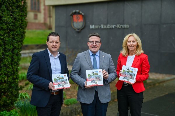 Landrat Christoph Schauder (Bildmitte) freut sich gemeinsam mit Ursula M�hleck, Dezernentin f�r Kreisentwicklung und Bildung, sowie Marcel Stephan, Amtsleiter f�r Wirtschaft und Klimaschutz, �ber die neue Imagebrosch�re. Die Publikation stellt die vielf�ltigen St�rken der Region als attraktiven Lebens-, Wirtschafts- und Bildungsstandort vor.