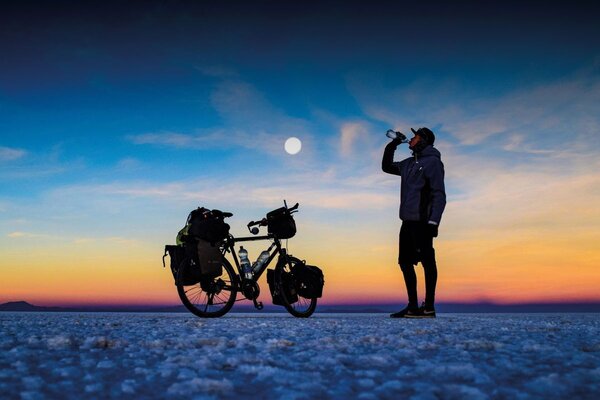 Das Foto zeigt einen Radfahrer vor einem Sonnenuntergang.