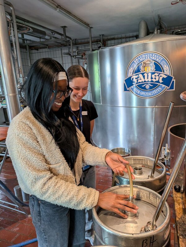 Bild vergr&ouml;&szlig;ern: Das Foto zeigt die Schülerinnen Maria Lucia Aikhionbare und Nele Römisch beim Abfüllen des Suds in der Brauerei Faust in Miltenberg.