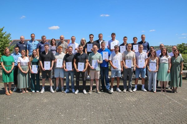 Strahlende Gesichter bei bestem Wetter: Die 18 Absolventen zum staatlich gepr�ften Techniker gemeinsam mit der Schulleitung und den Lehrkr�ften der Gewerblichen Schule Tauberbischofsheim.