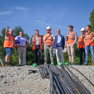 Einblicke vor Ort: Landrat Christoph Schauder (2.v.l.) hat sich gemeinsam mit B&uuml;rgermeister Dr. Lukas Braun (5.v.r.) sowie weiteren Vertretern des Regierungspr&auml;sidiums Stuttgart und des Amtes f&uuml;r Stra&szlig;en- und Radwegebau des Landratsamtes Main-Tauber-Kreis die Baustelle der Gr&uuml;nbachbr&uuml;cke in Gerlachsheim angeschaut.