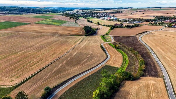 Wichtiger L�ckenschluss im malerischen Ambiente: Bisher mussten Radfahrer die schmale Kreisstra�e 2808 (rechts im Bild) nutzen. Der neue Radweg schl�ngelt sich zwischen Feldern und Wiesen neben der Kreisstra�e. 