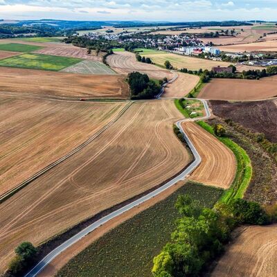 Wichtiger L�ckenschluss im malerischen Ambiente: Bisher mussten Radfahrer die schmale Kreisstra�e 2808 (rechts im Bild) nutzen. Der neue Radweg schl�ngelt sich zwischen Feldern und Wiesen neben der Kreisstra�e. 
