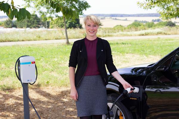 Anna Mhleck, Leiterin der Organisationsentwicklung bei BASS und fr das Energiemanagement mitverantwortlich mit einem Elektrofahrzeug an einer der beiden neuen E-Ladesulen.