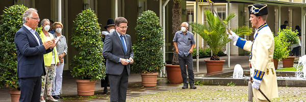 Der scheidende Vorsitzende des Tourismusverbandes "Liebliches Taubertal", Reinhard Frank (links), und der neue Vorsitzende, Landrat Christoph Schauder, nehmen die Grüße der Historischen Deutschorden-Companie entgegen.