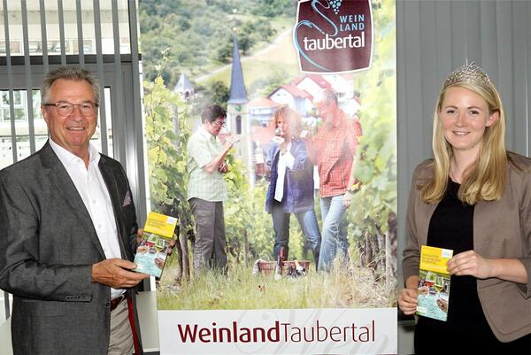 Geschftsfhrer Jochen Mssig und die Taubertler Weinknigin Michaela prsentieren den neuen Flyer "Weingter im Weinland Taubertal". Gleichzeitig gratulierte Mssig Michaela Wille zur Wahl zur badischen Weinprinzessin.