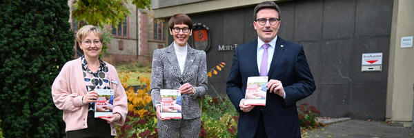 Die Leiterin des Amtes f�r Pflege und Versorgung, Nicole Schwarz, und Sozialdezernentin Elisabeth Krug �bergaben das erste Exemplar des neuen Seniorenwegweisers an Landrat Christoph Schauder (von links).