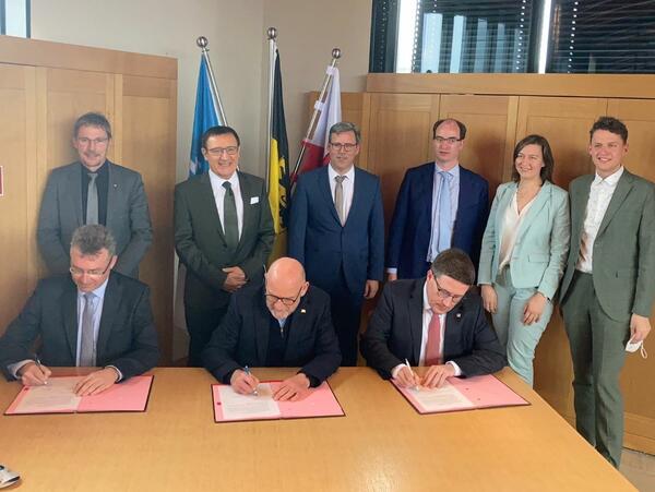 Bild vergr&ouml;&szlig;ern: Das Foto zeigt die Vertragsunterzeichnung zur Verlängerung des Probebetriebs auf der Frankenbahn mit Landrat Dr. Achim Brötel (Neckar-Odenwald-Kreis, Verkehrsminister Winfried Hermann und Landrat Christoph Schauder (Main-Tauber-Kreis). Mit ihnen freuten sich die Bürgermeisterin und die Bürgermeister der anliegenden Kommunen sowie der Landtagsabgeordnete aus dem Main-Tauber-Kreis, Jürgen Galm (Osterburken), Prof. Dr. Wolfgang Reinhart, Ralph Matousek (Rosenberg), Dr. Lukas Braun (Lauda-Königshofen), Heidrun Beck (Boxberg) und Benjamin Czernin (Ahorn).