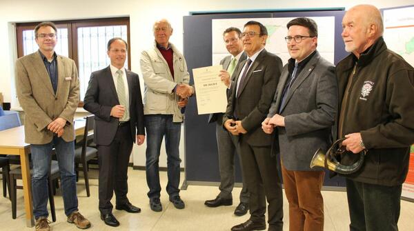�bergabe des Bewilligungsbescheides an den Vorsitzenden der Teilnehmergemeinschaft Assamstadt (Wald) (von links): Dezernent Dr. Thomas Winter (Hohenlohekreis), B�rger-meister Joachim D�ffinger (Assamstadt), Vorsitzender Hans-J�rgen Oehme, Minister Peter Hauk, Landtagsvizepr�sident Prof. Dr. Wolfgang Reinhart, Landrat Christoph Schauder und ein Vertreter der Jagdhornbl�ser.