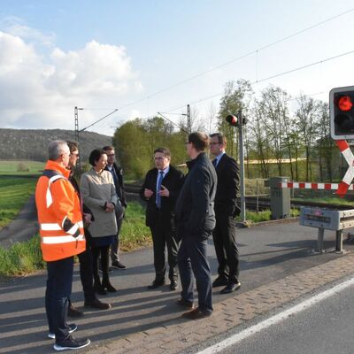 Die Delegation des Regierungspräsidiums besichtigt den Doppelbahnübergang in Königshofen zusammen mit Landrat Christoph Schauder, Erstem Landesbeamten Florian Busch, Straßenbauamtsleiter Markus Metz und Bürgermeister Dr. Lukas Braun.