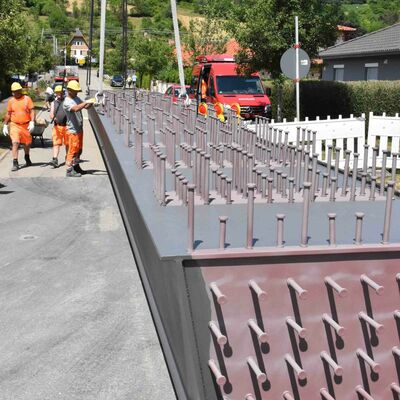 Die per Schwertransport angelieferten Stahlhohlkästen wurden zunächst von den Arbeitern des Bauunternehmens Leonhard Weiss mit Ketten am Kran befestigt.