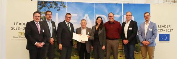 Bild vergr&ouml;&szlig;ern: Das Foto zeigt die Urkundenübergabe für die LEADER-Aktionsgruppe Hohenlohe-Tauber: Landrat Christoph Schauder, Dezernent Dr. Thomas Winter (Hohenlohekreis), Minister Peter Hauk MdL, Vorsitzender Hermann Limbacher, Amtsleiterin Caroline Bogenschütz (Hohenlohekreis), Geschäftsführer Thomas Schultes, stellvertretender Vereinsvorsitzender Rüdiger Zibold, David Schneider (Schwäbisch Hall).