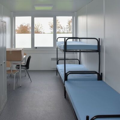 In jedem Schlafraum in der neuen Gemeinschaftsunterkunft stehen jeweils drei Betten und Spinde, ein Tisch mit St&uuml;hlen sowie ein K&uuml;hlschrank zur Verf&uuml;gung.