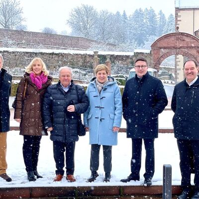 Kulturamtsleiter Frank Mittnacht (von links), Gästeführer Kurt Lindner, Dezernentin Ursula Mühleck, Altlandrat Georg Denzer, Ministerin Nicole Razavi MdL, Landrat Christoph Schauder, Prof. Dr. Gerhard Sextl (Institutsleiter des Fraunhofer Instituts für Silicatforschung) und Joachim Aragón (Leiter des Amtes für Immobilienmanagement) vor dem Kloster Bronnbach.