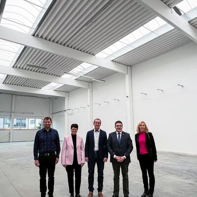 Noch ist die frisch renovierte Halle leer, hier steht zuknftig ein Teil der neuen Pulverbeschichtungsanlage. Die kaufmnnische Geschftsfhrerin Gabriela Knig (2.v.l.) und Heiko Wolz (Bildmitte), technischer Geschftsfhrer, fhrten Landrat Christoph Schauder (2.v.r.) und Ursula Mhleck (r.), Dezernentin fr Kreisentwicklung und Bildung beim Landratsamt Main-Tauber-Kreis, gemeinsam mit Personalleiter Sebastian Sturm (l.) durch die drei Werke am Standort.