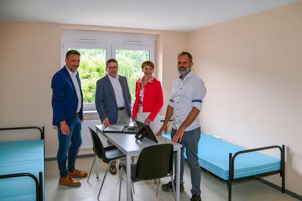 �ber die bevorstehende Fertigstellung der generalsanierten Gemeinschaftsunterkunft �Zwischen den B�chen� in Bad Mergentheim freuen sich, hier in einem der k�nftigen Zweibettzimmer (von links): Finanzdezernent Torsten Hauck, Landrat Christoph Schauder, Sozialdezernentin Elisabeth Krug und der Amtsleiter f�r Immobilienmanagement, Joachim Arag�n.
