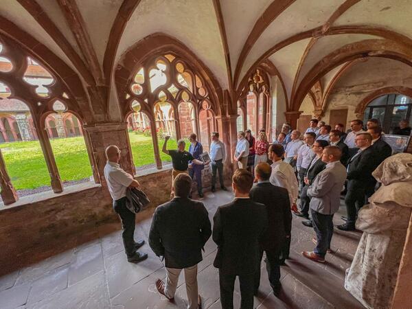 Das Foto zeigt den Kreuzganginnenhof des Klosters Bronnbach: Gästeführer Kurt Lindner informierte die Führungsriege des Transporthubschrauberregiments 30 aus Niederstetten und die des Landratsamtes Main-Tauber-Kreis über die Baugeschichte des Klosters.